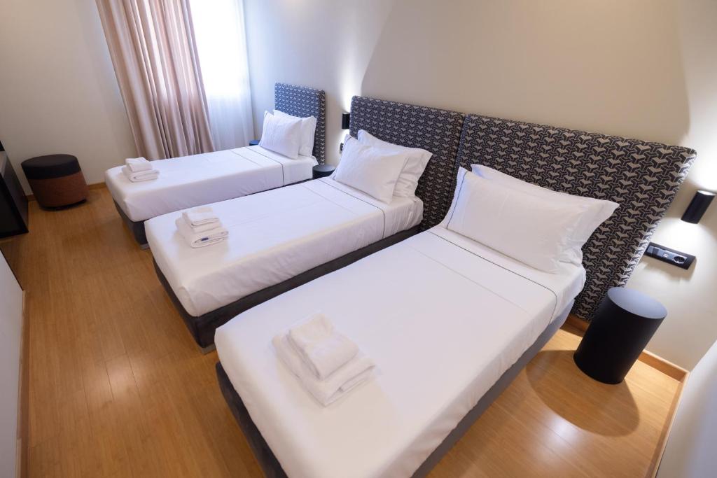 Triple Room - Perfect for families or groups, featuring three comfortable beds with organic linens